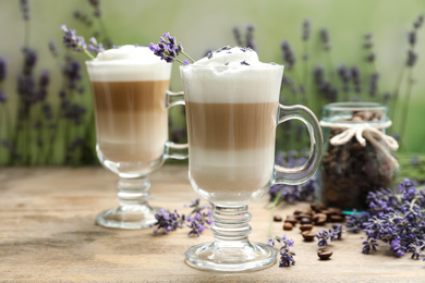 Delicious latte with lavender and coffee beans on wooden table