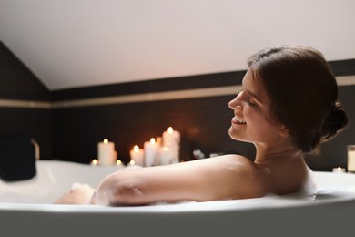 Photo of Happy beautiful woman taking bubble bath. Romantic atmosphere