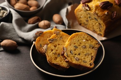 Cut pumpkin bread with pecan nuts on wooden table