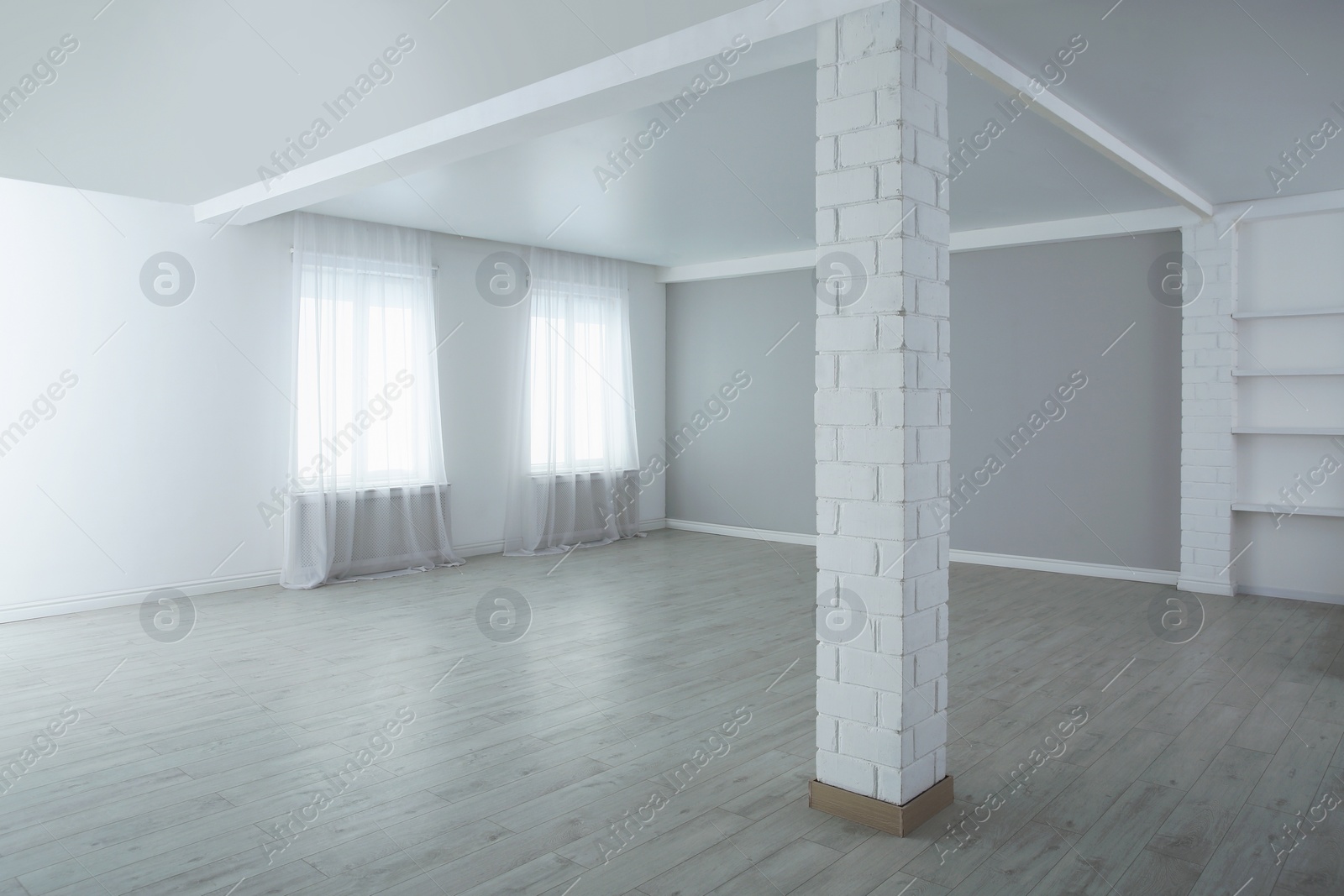 Photo of Empty room with large windows and laminated floor