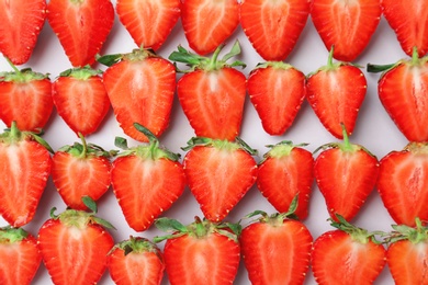 Photo of Flat lay composition with cut ripe strawberries on light background