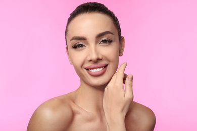 Photo of Beautiful woman with matte lipstick on pink background