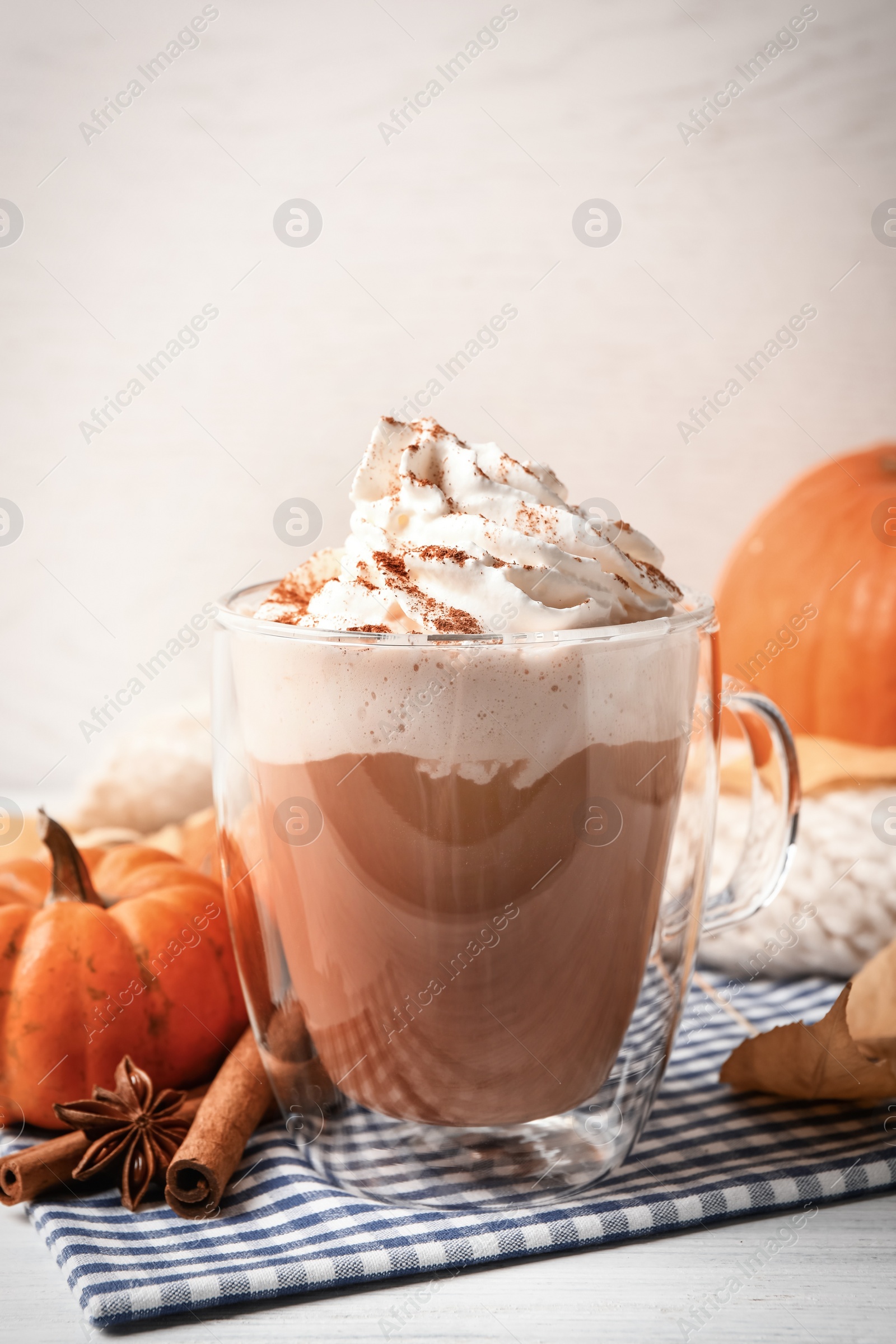 Photo of Delicious pumpkin latte with whipped cream on table, closeup