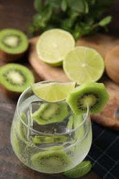 Photo of Glass of refreshing drink with kiwi and lime on table