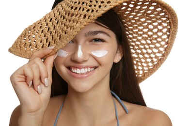 Teenage girl with sun protection cream on her face against white background