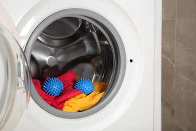 Blue dryer balls and clothes in washing machine drum