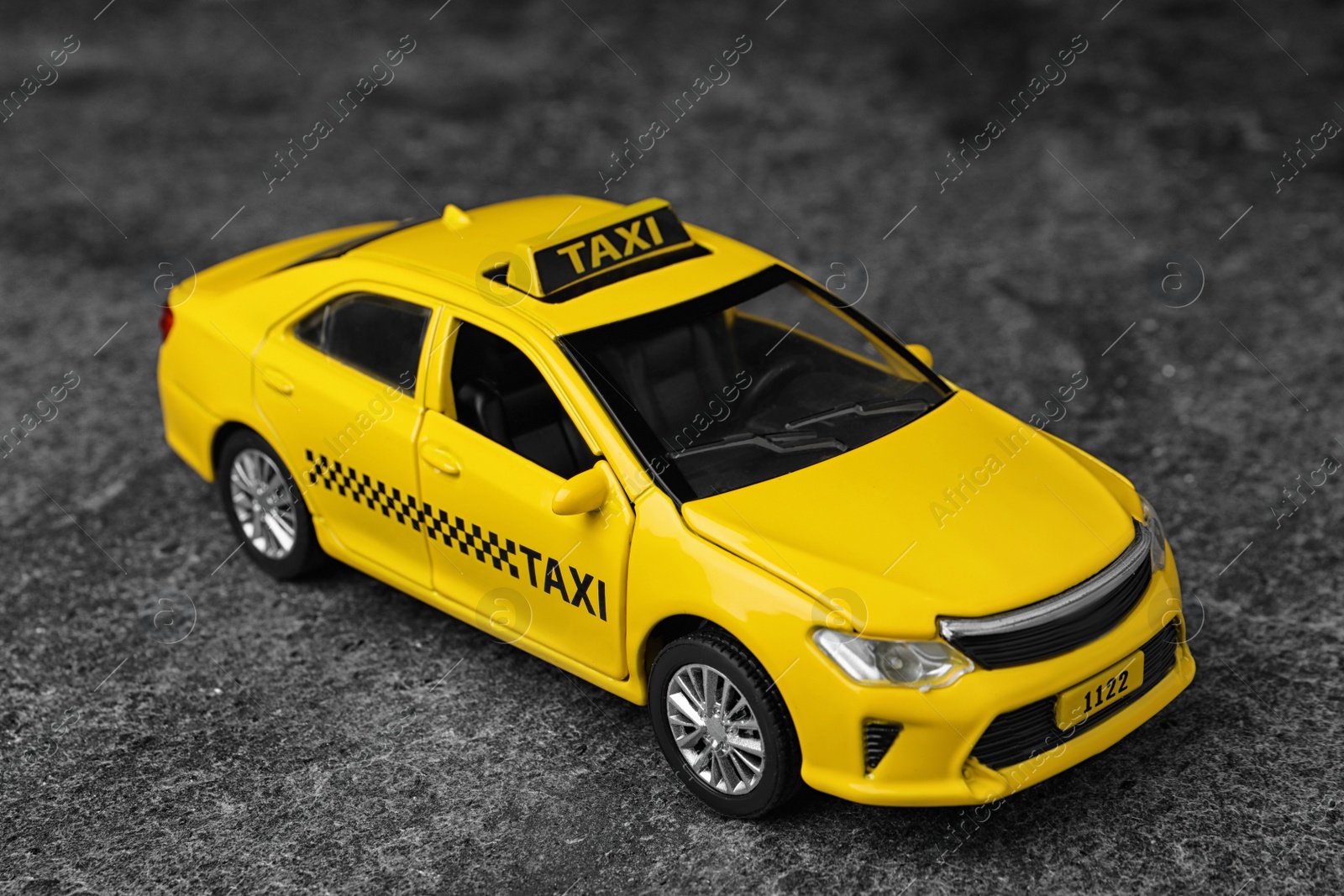 Photo of Yellow taxi car model on grey background