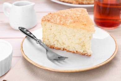 Photo of Piece of tasty sponge cake on white wooden table