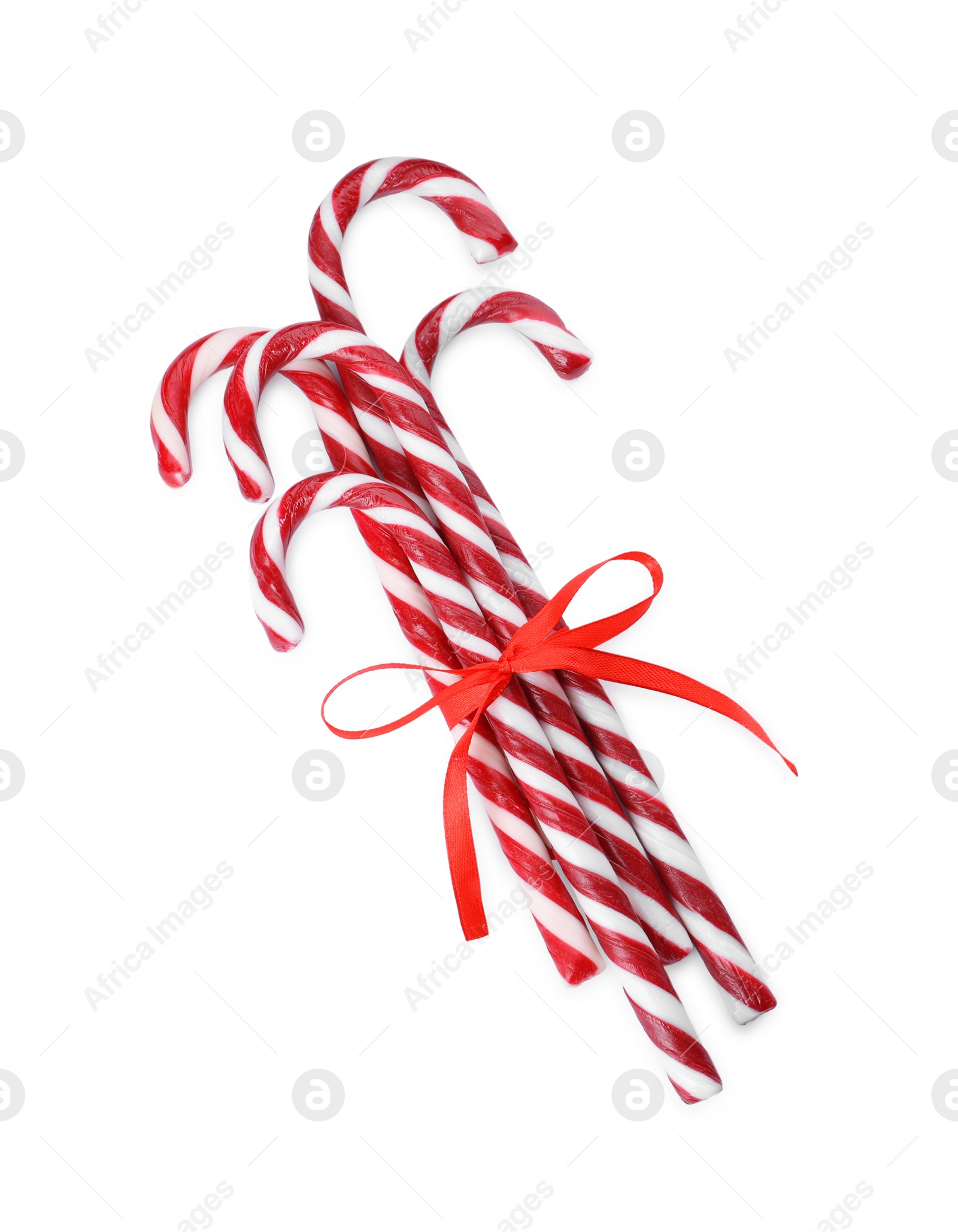 Photo of Sweet Christmas candy canes with red bow on white background, top view