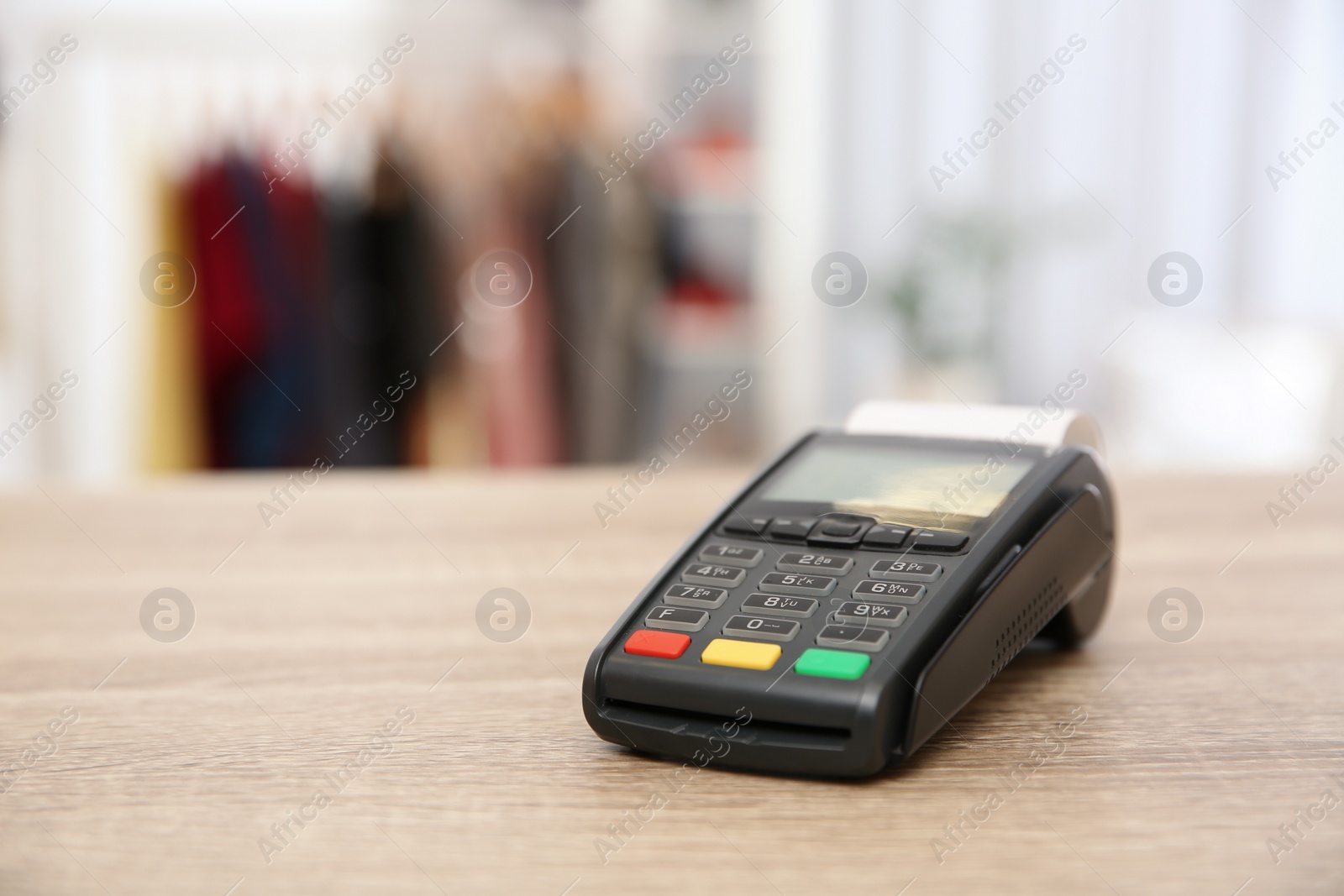 Photo of Payment terminal on counter in shop. Space for text