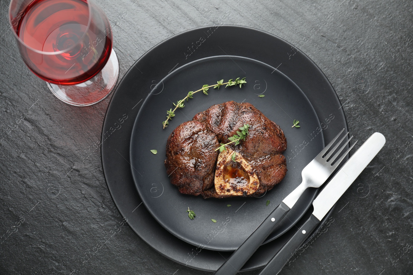 Photo of Tasty grilled beef meat served on black table, flat lay