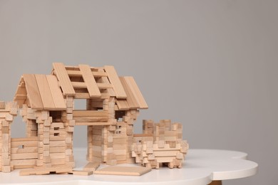 Wooden entry gate and building blocks on white table against grey background, space for text. Children's toy