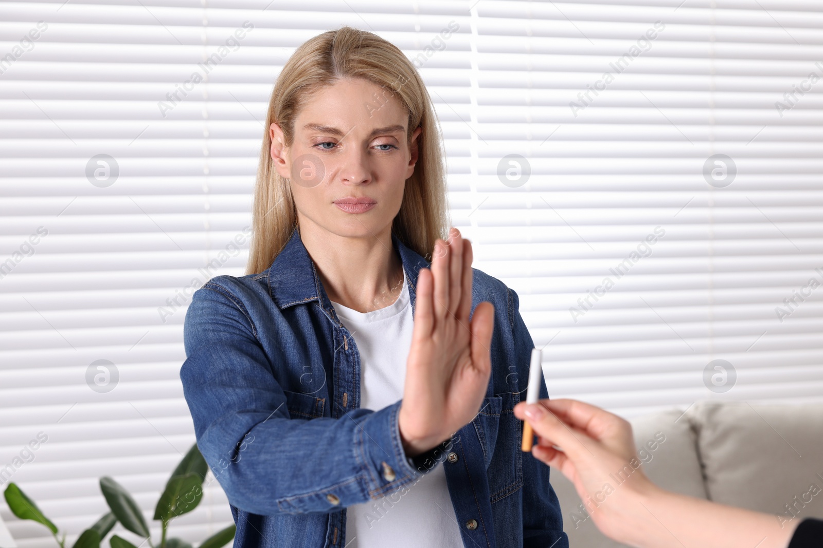 Photo of Woman refusing cigarette at home. Quitting smoking concept