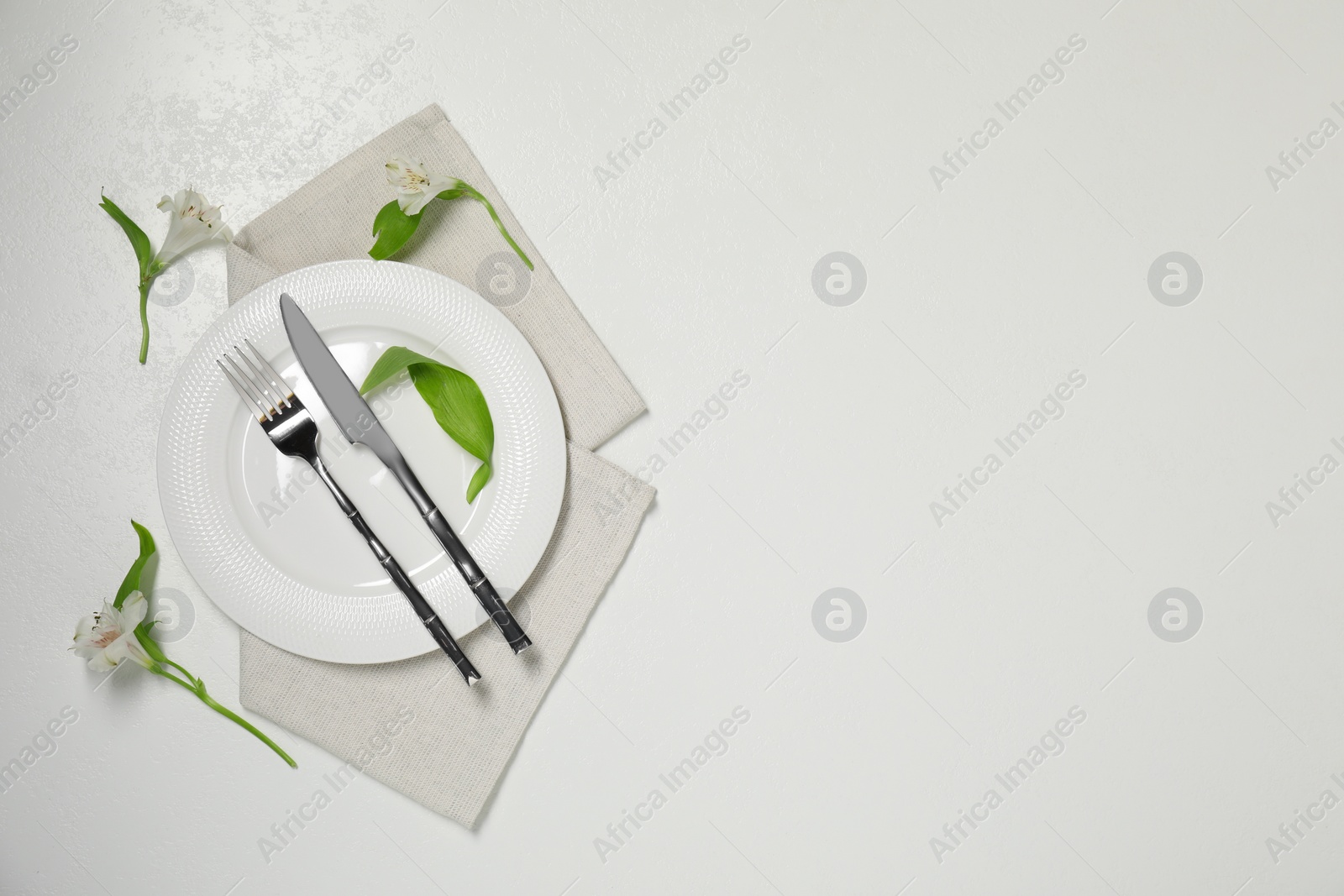 Photo of Stylish setting with elegant cutlery on white table, top view. Space for text