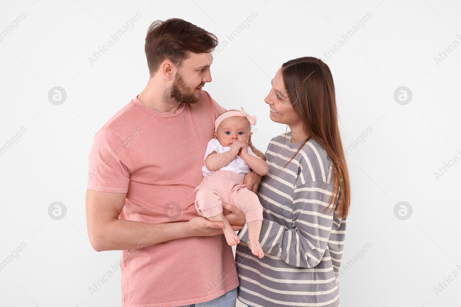 Photo of Happy family. Parents with their cute baby on light background