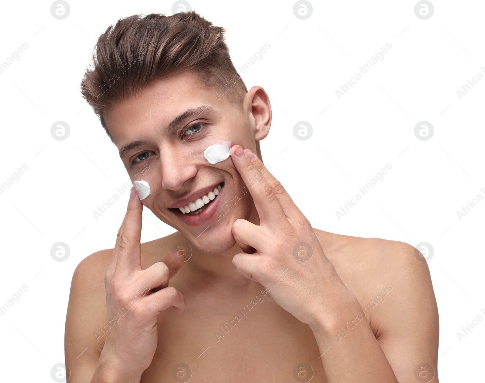 Photo of Handsome man applying moisturizing cream onto his face on white background