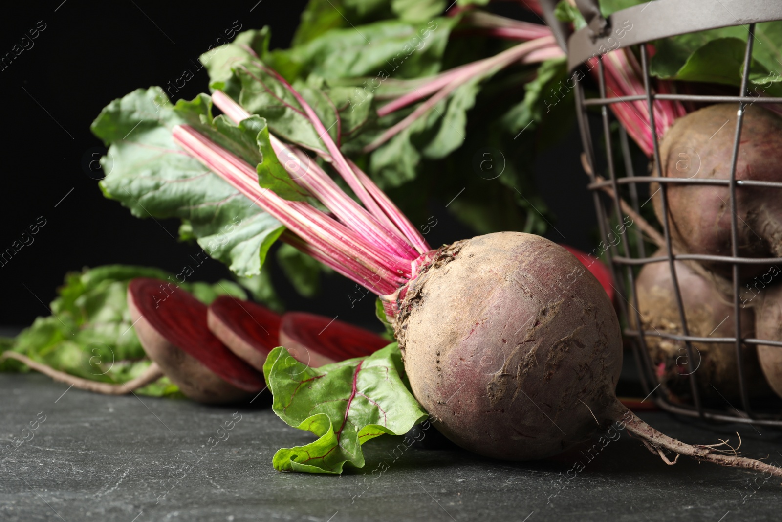 Photo of Whole ripe beets on black table, closeup