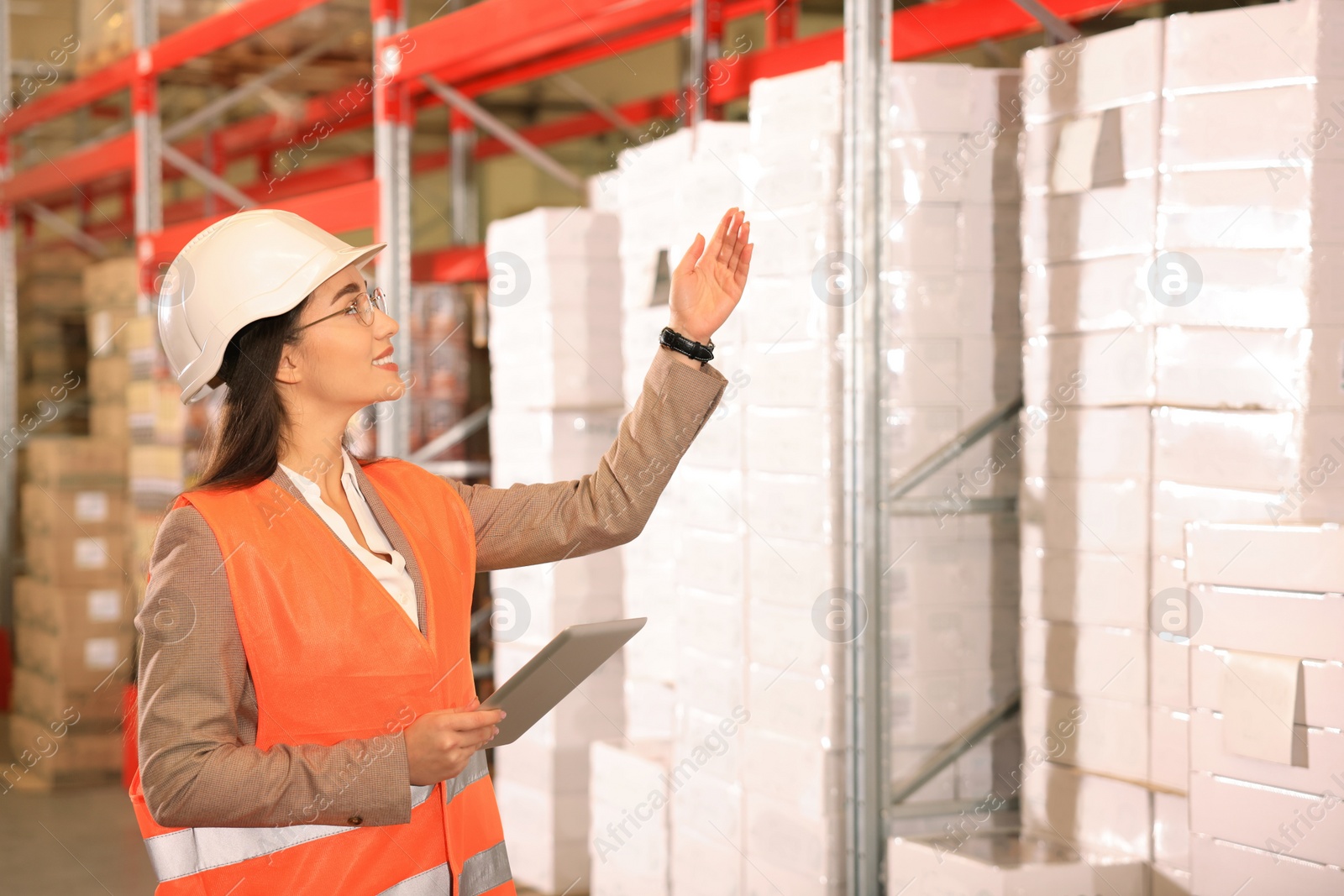 Image of Woman with tablet working at warehouse. Logistics center