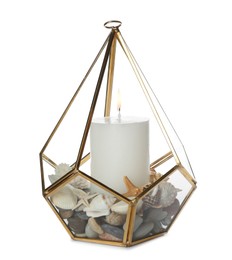 Photo of Stylish glass holder with burning candle, seashells and pebbles isolated on white