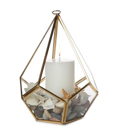 Stylish glass holder with burning candle, seashells and pebbles isolated on white