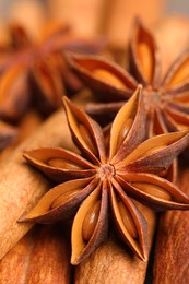 Aromatic anise stars on cinnamon sticks as background, closeup