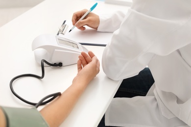 Photo of Doctor checking patient's blood pressure in hospital