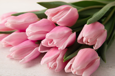 Beautiful pink spring tulips on white wooden background, closeup