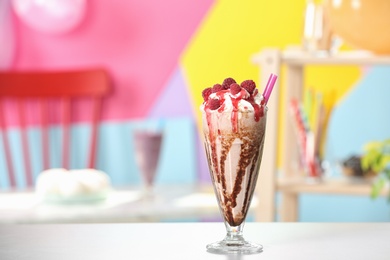 Tasty milk shake with topping on white table indoors. Space for text