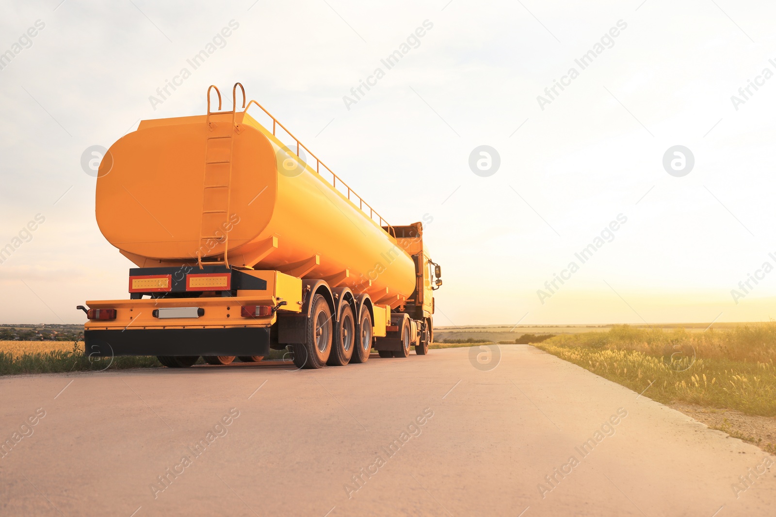 Photo of Modern yellow truck on country road. Space for text