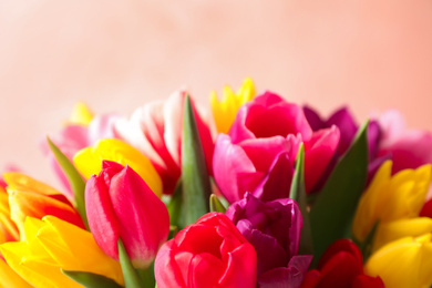 Photo of Beautiful spring tulips on light pink background, closeup