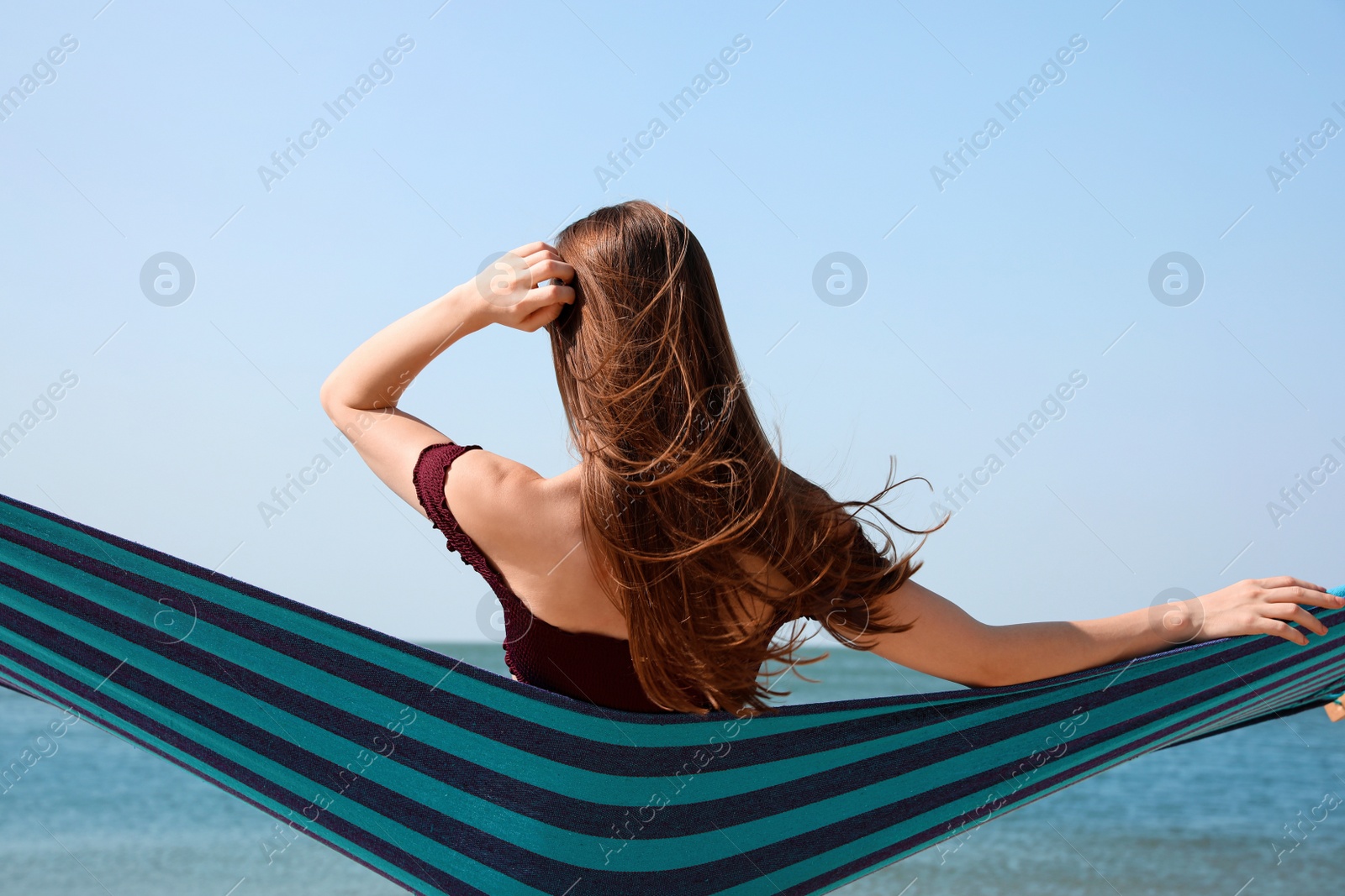 Photo of Young woman relaxing in hammock on beach