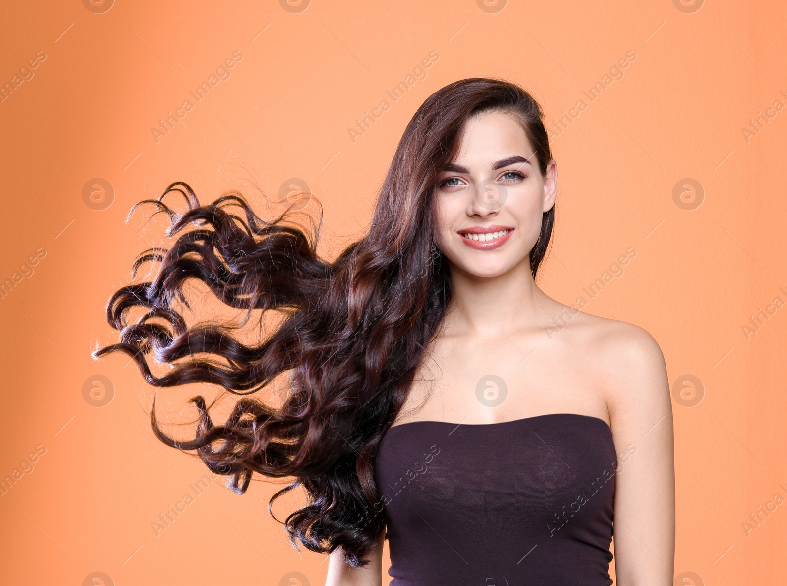 Photo of Portrait of beautiful model with gorgeous curly hair on color background