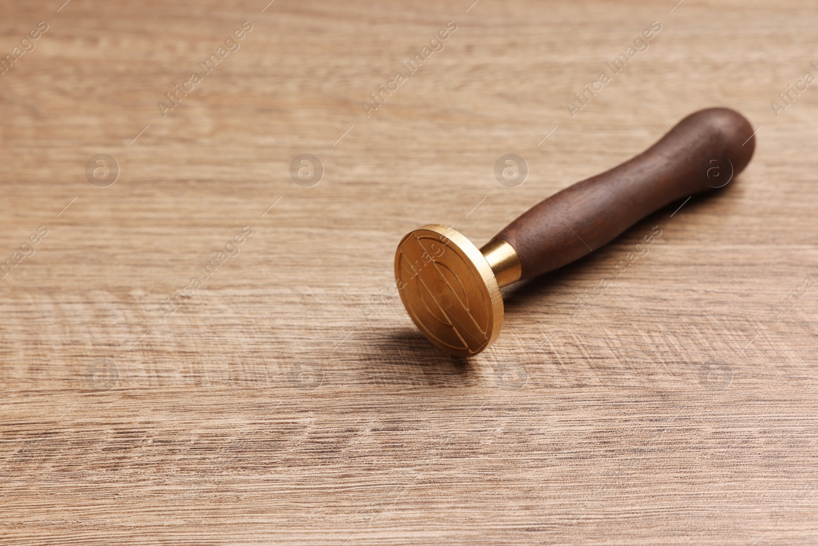 Photo of One stamp tool on wooden table, closeup. Space for text