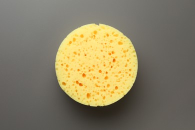 Photo of New yellow sponge on grey background, top view