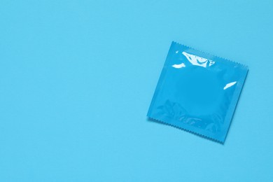 Photo of Condom package on light blue background, top view and space for text. Safe sex