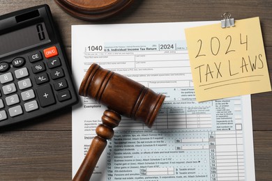 2024 tax laws. Flat lay composition with paper note and form on wooden table
