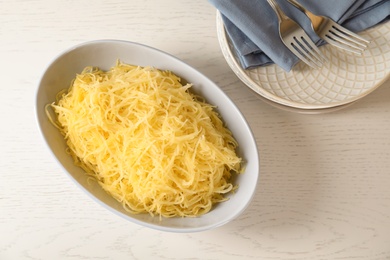 Photo of Cooked spaghetti squash in bowl on table, top view
