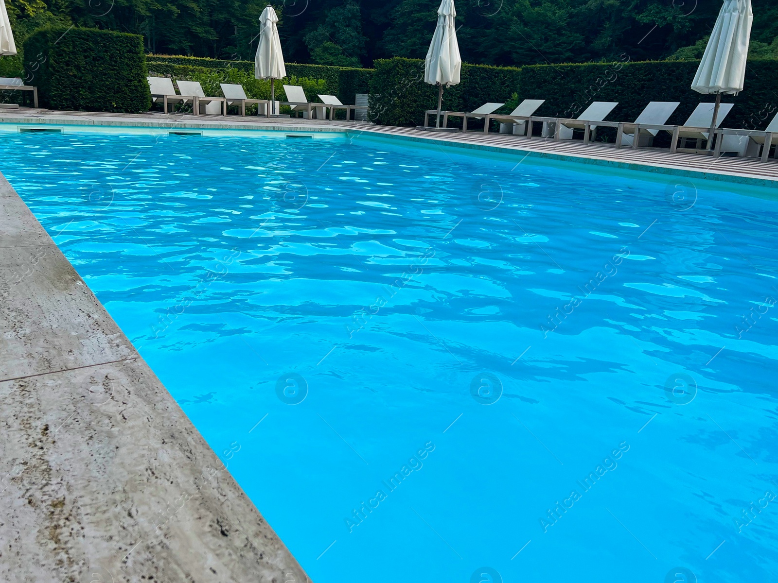 Photo of Outdoor swimming pool in luxury hotel on sunny summer day. Time for relax