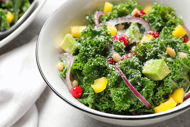 Tasty fresh kale salad on grey table, closeup