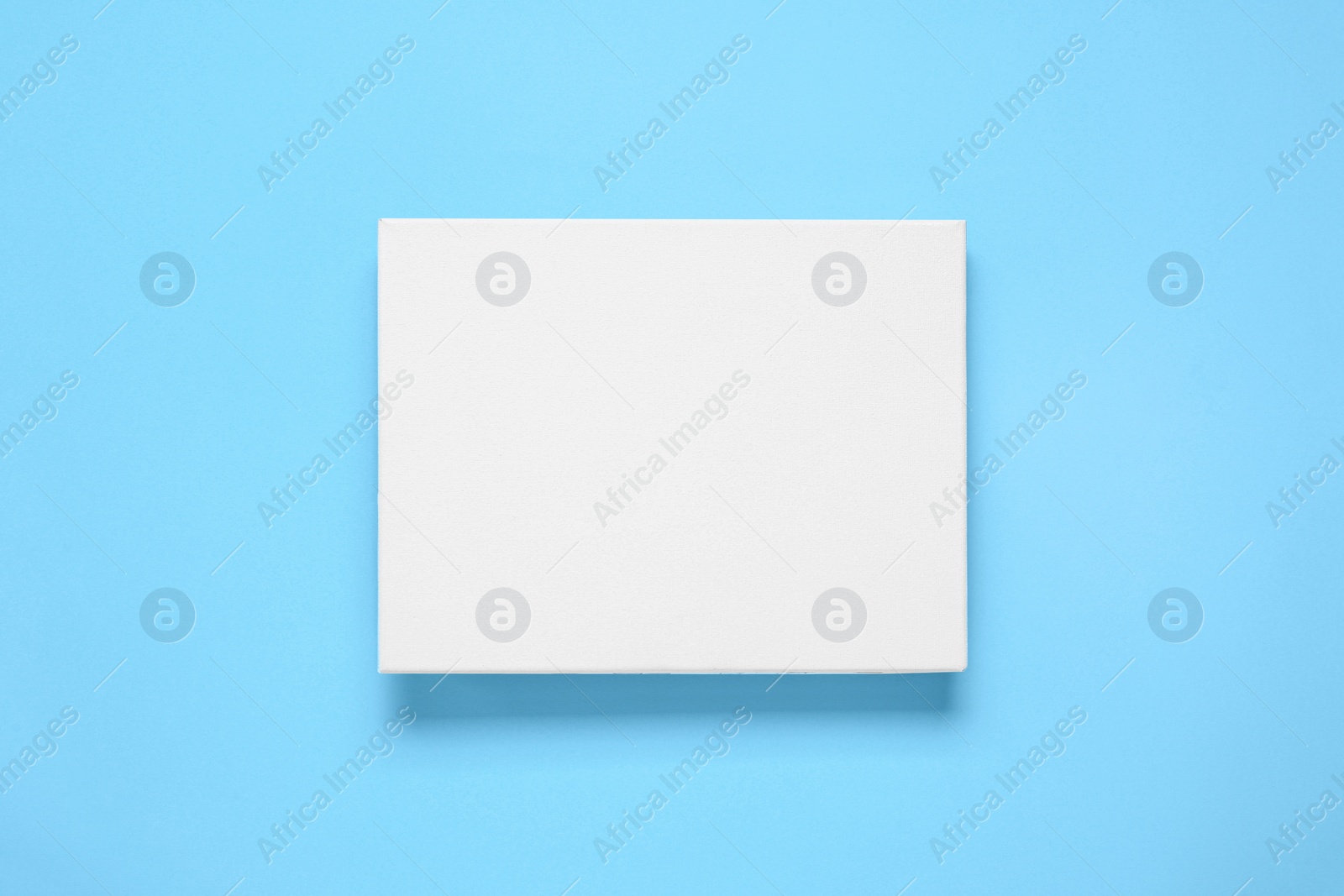 Photo of Blank canvas on light blue background, top view. Space for design