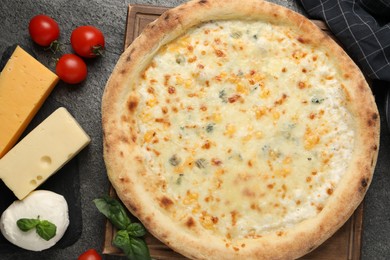 Photo of Delicious cheese pizza and ingredients on dark grey table, flat lay