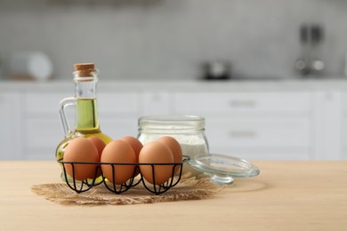 Eggs, flour and oil on wooden table in kitchen. Space for text