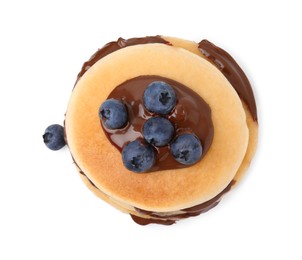 Photo of Tasty pancakes with chocolate spread and blueberries isolated on white, top view