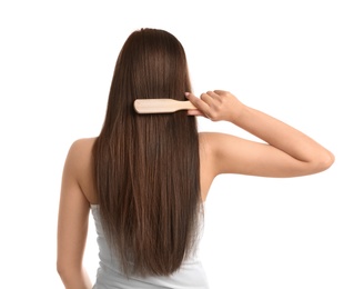 Photo of Back view of young woman with hair brush on white background