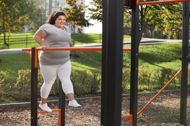 Photo of Beautiful overweight woman training on sports ground