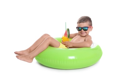 Cute little boy with inflatable ring and glass of cocktail on white background