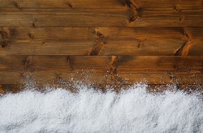 Photo of Snow and space for text on wooden background, top view. Christmas time