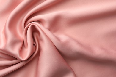 Photo of Crumpled pink silk fabric as background, top view