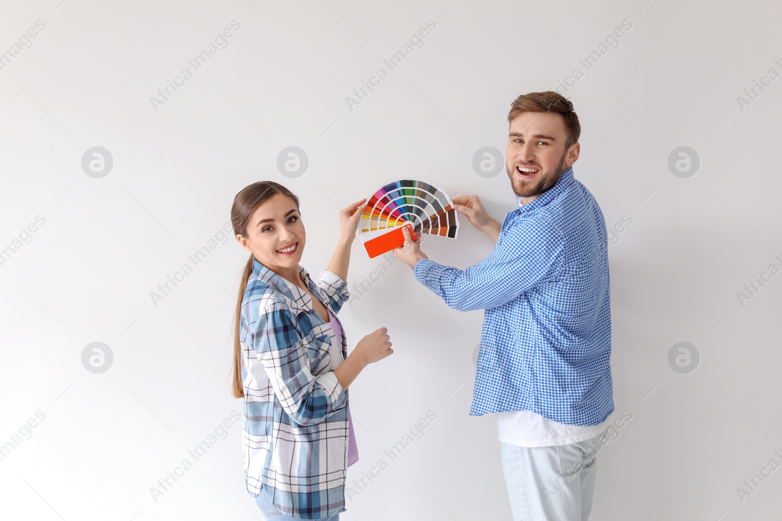 Photo of Young couple with color palette on white background