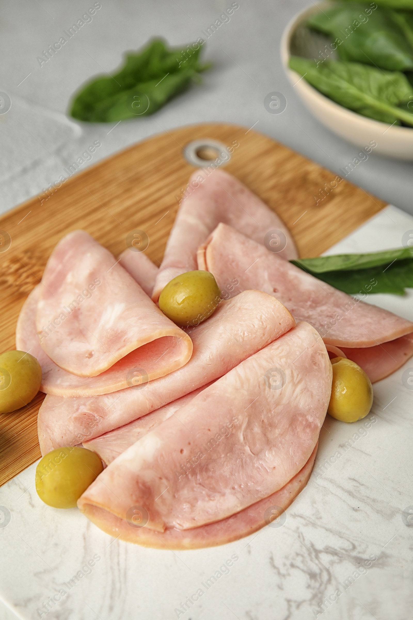 Photo of Ham with olives and spinach on table